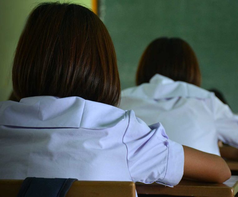 Estudantes realizando avaliação em sala de aula, uma das ações estruturantes ao combate do analfabetismo funcional.