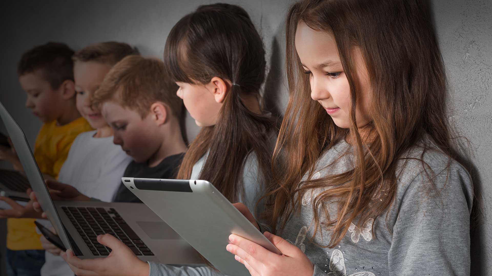 Estudantes usando dispositivos tecnológicos em sala de aula, destacando a importância do letramento em IA para que a interação com sistemas de Inteligência Artificial seja feita de maneira crítica, consciente e ética.